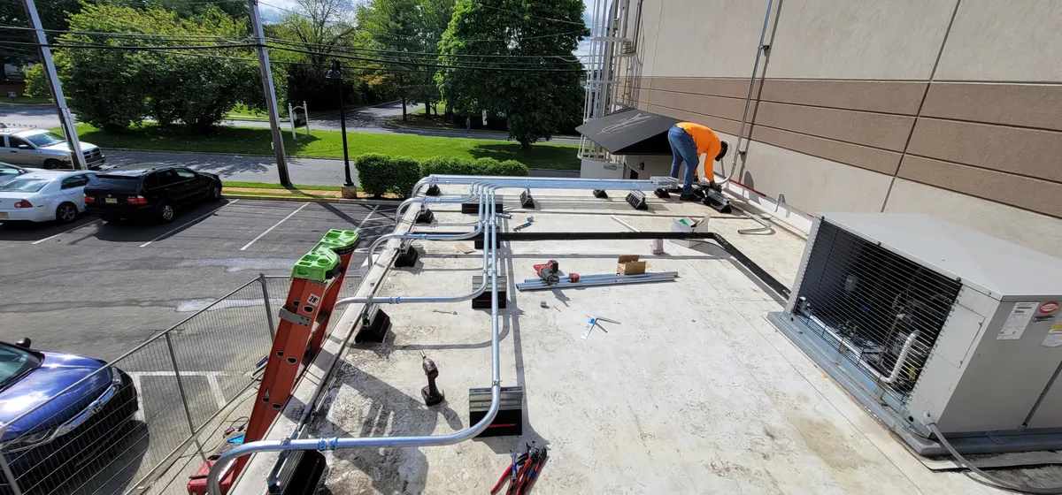 Commercial rooftop electrical conduit runs installed and organized