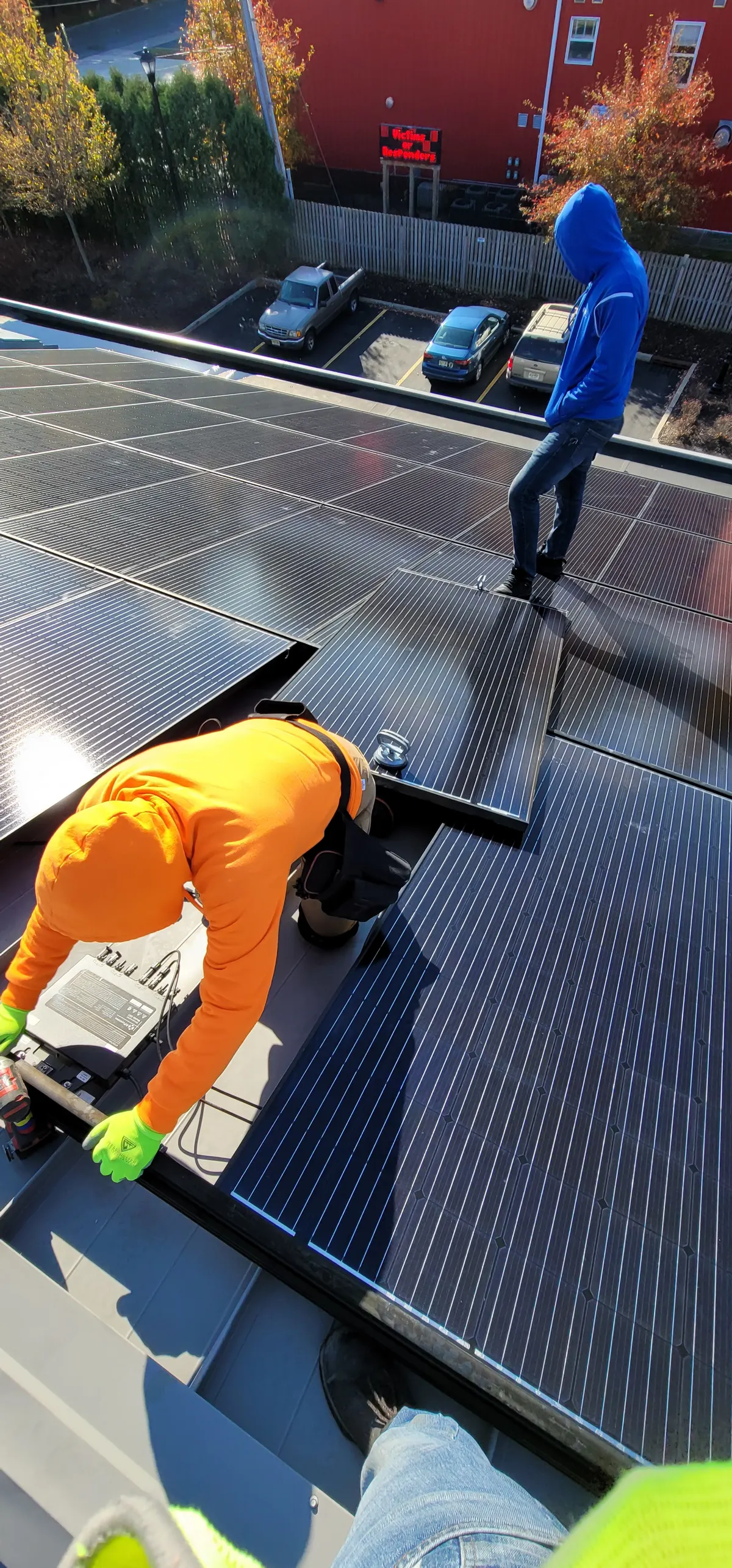 Technicians inspecting a commercial rooftop solar panel array