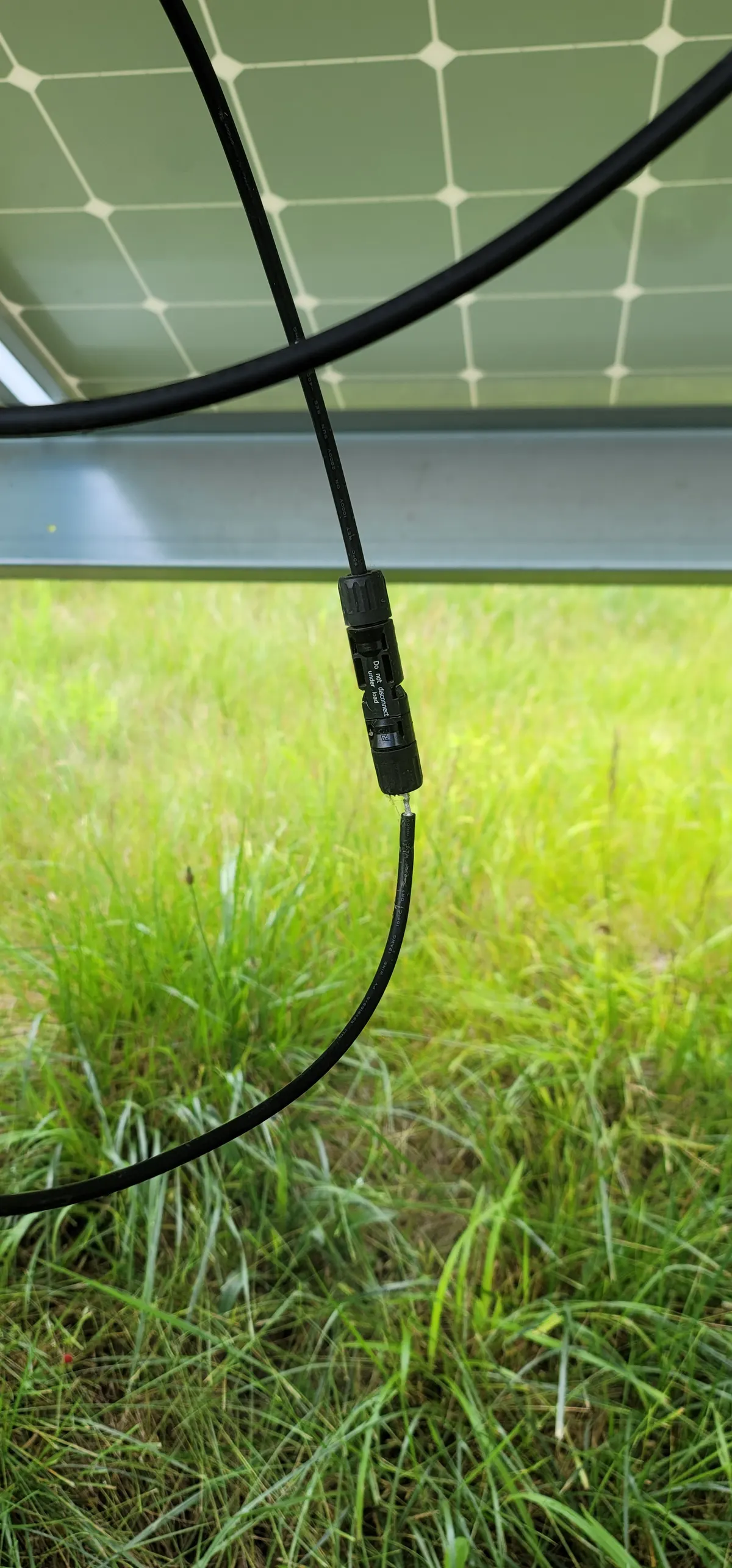 Ground-mount solar MC4 connector inspected for secure connection