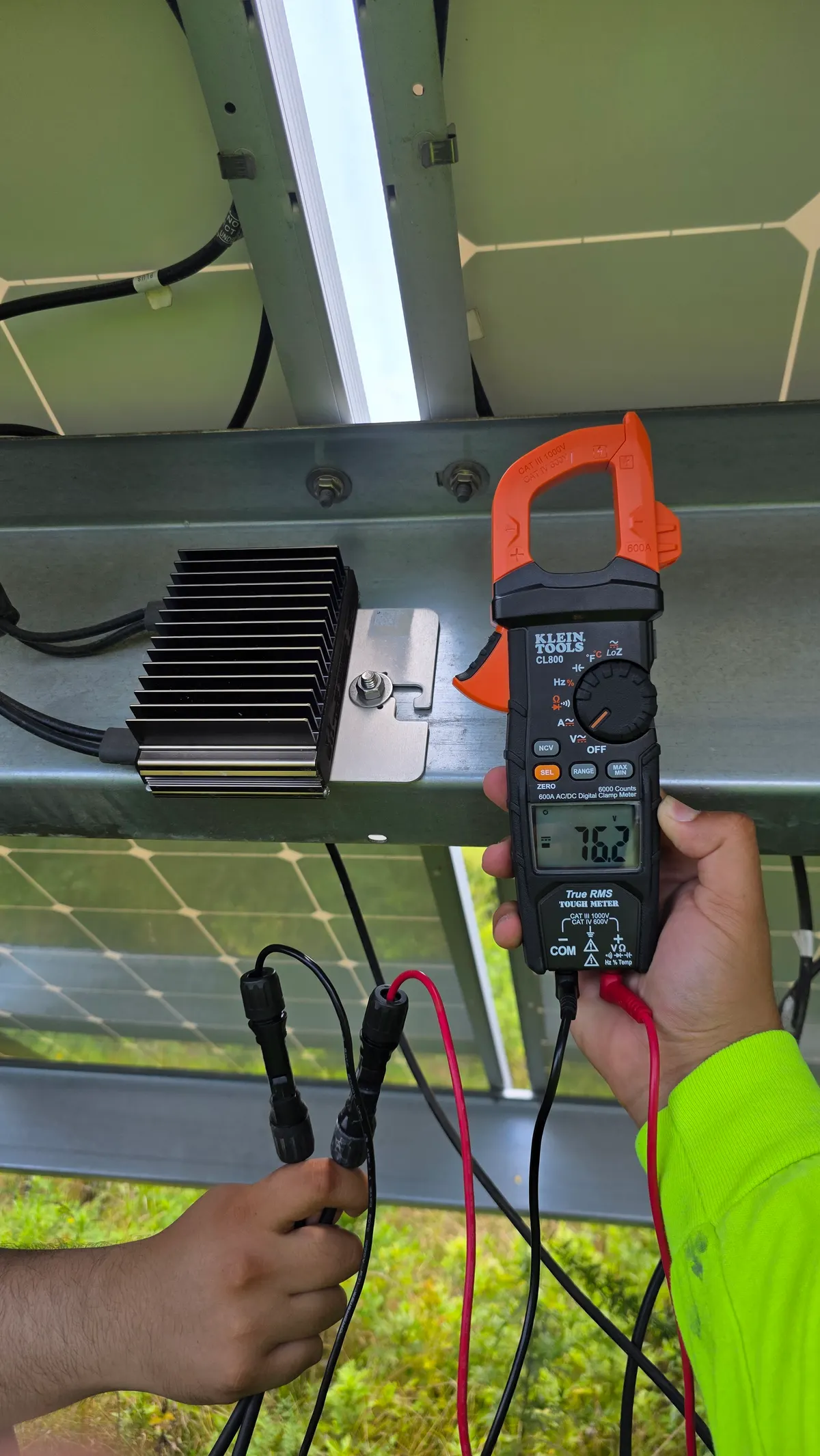 String voltage test on a ground-mount solar array with a clamp meter in Lancaster PA