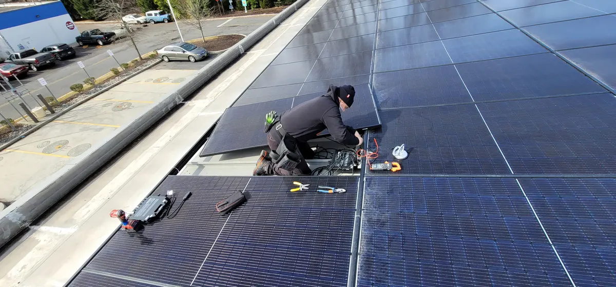 Technician performing preventive maintenance on a rooftop solar array