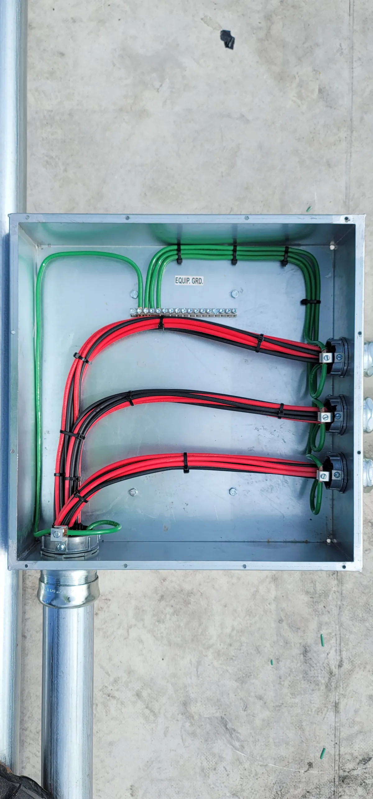 Organized DC junction box with red and black conductors and equipment grounding
