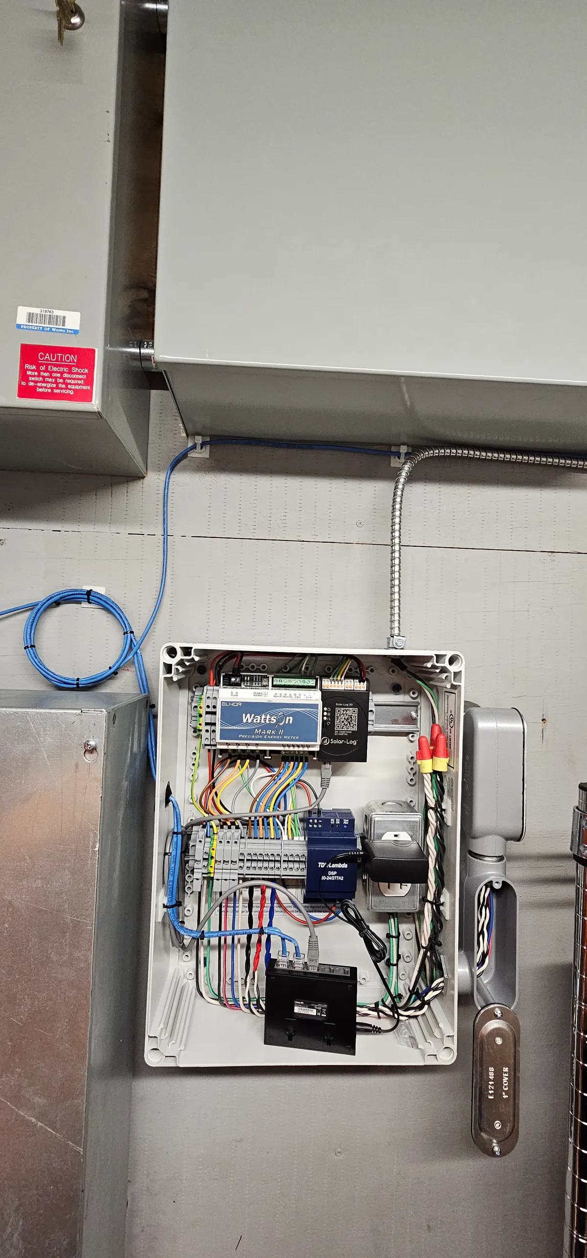 Solar monitoring system enclosure with Wattson Mark II energy meter inspected during preventive maintenance